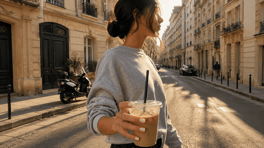 femme dans la rue tenant un café avec des ongles faits, type recession nails